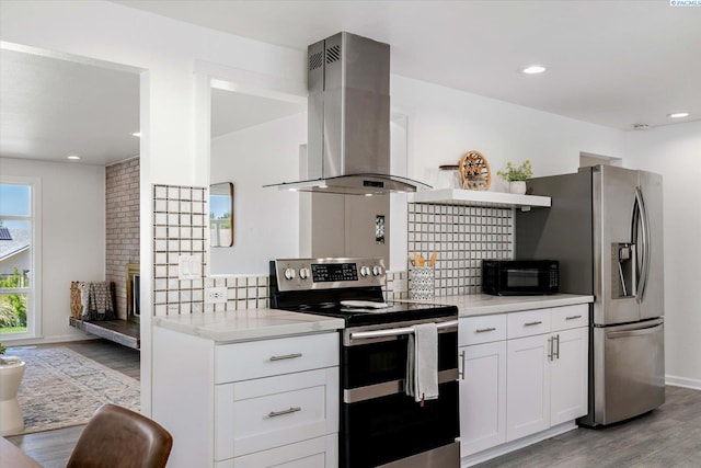2115 W 8th Pl, Kennewick, WA 99336 - kitchen with island range hood, appliances with stainless steel finishes, light wood-style flooring, decorative backsplash, and light countertops
