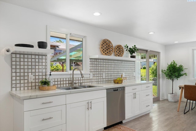 2115 W 8th Pl, Kennewick, WA 99336 - kitchen with stainless steel dishwasher, a sink, backsplash, light wood-style flooring, and white cabinets