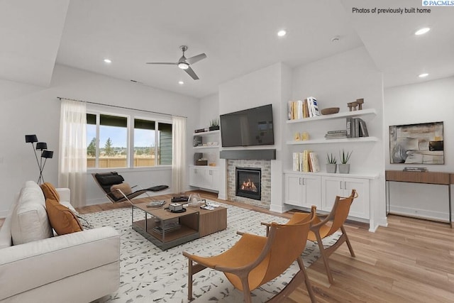2817 Avrio Ave, Richland, WA 99354 - living area featuring light wood finished floors, a glass covered fireplace, a ceiling fan, recessed lighting, and baseboards