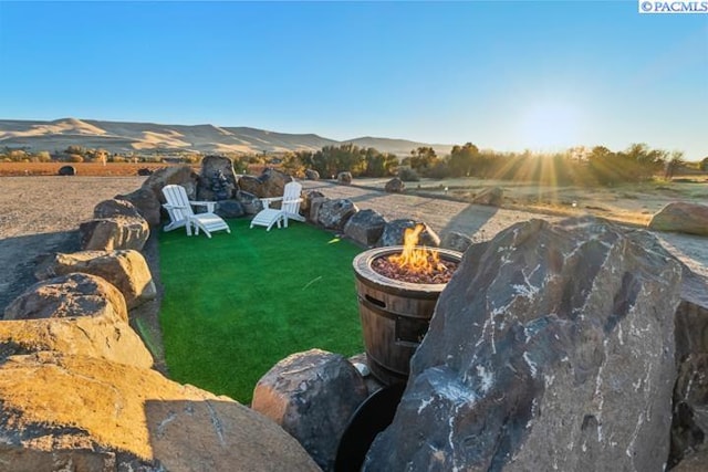 view of yard with an outdoor fire pit and a mountain view