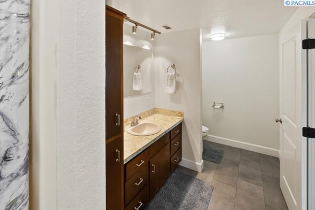 bathroom featuring vanity, tile patterned floors, and toilet