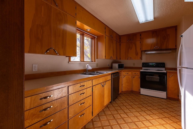 kitchen featuring sink, white appliances, and a textured ceiling