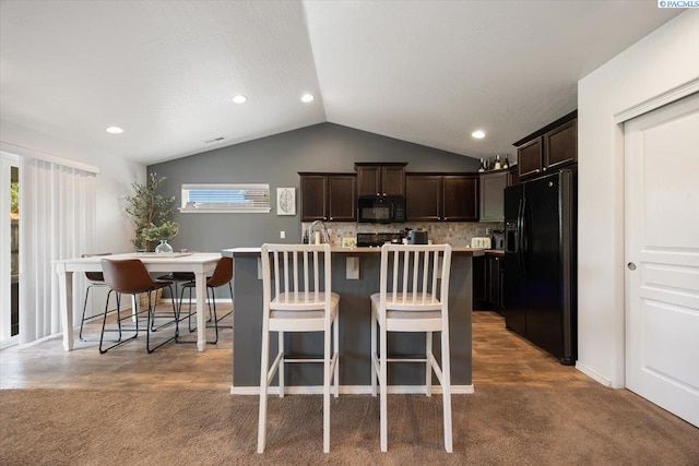 2909 S Jean St, Kennewick, WA 99336 - kitchen with black appliances, lofted ceiling, dark brown cabinetry, carpet floors, and a breakfast bar