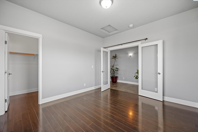 874 Pikes Peak Dr, West Richland, WA 99353 - unfurnished bedroom featuring french doors, baseboards, attic access, wood finished floors, and a spacious closet
