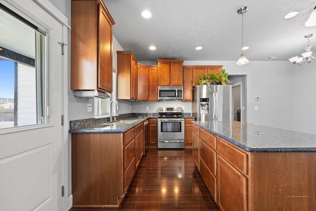 874 Pikes Peak Dr, West Richland, WA 99353 - kitchen with stainless steel appliances, a sink, healthy amount of natural light, brown cabinetry, and recessed lighting