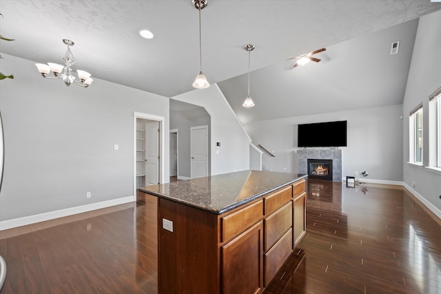 874 Pikes Peak Dr, West Richland, WA 99353 - kitchen with a tile fireplace, dark wood-style flooring, ceiling fan, baseboards, and lofted ceiling