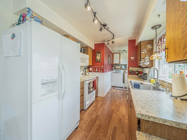 902 W 44th Pl, Kennewick, WA 99337 - kitchen with white appliances, washer / dryer, track lighting, wood finished floors, and light countertops
