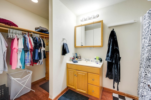815 NE Illinois St, Pullman, WA 99163 - full bath with a walk in closet, vanity, baseboards, and wood finished floors