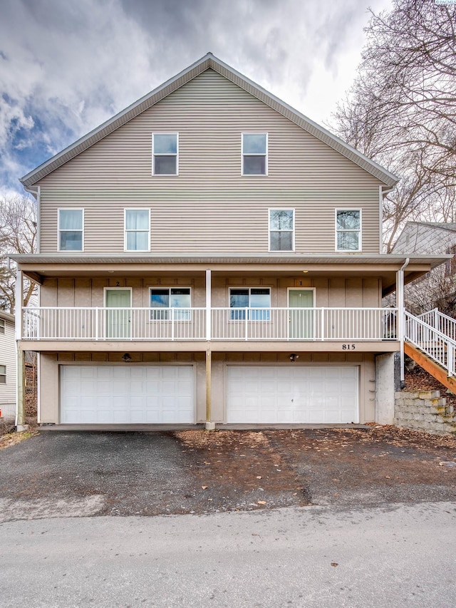 exterior space featuring stairs, aphalt driveway, and a garage