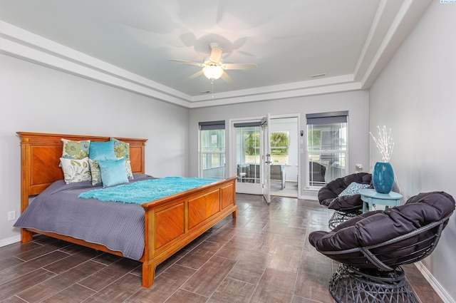 bedroom featuring french doors, a raised ceiling, dark wood-style floors, and access to exterior