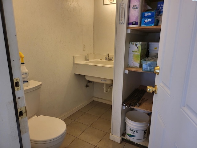 bathroom with tile patterned floors, baseboards, and toilet