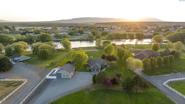 aerial view at dusk with a water view and a residential view