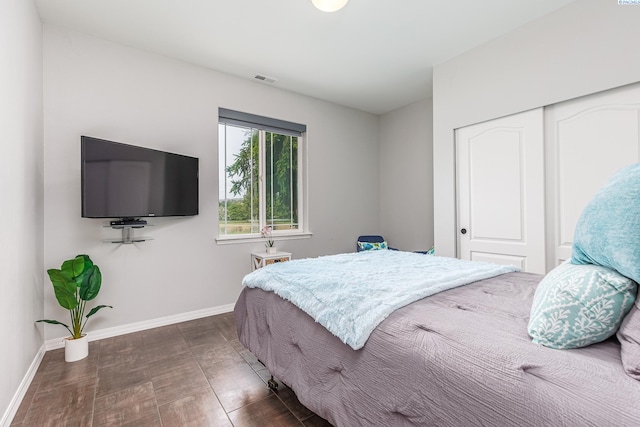 bedroom featuring baseboards, visible vents, and a closet