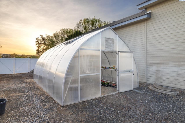 view of greenhouse featuring fence