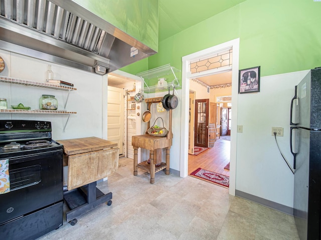 kitchen with black / electric stove and fridge