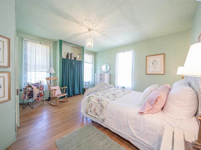 bedroom with a notable chandelier and light hardwood / wood-style floors