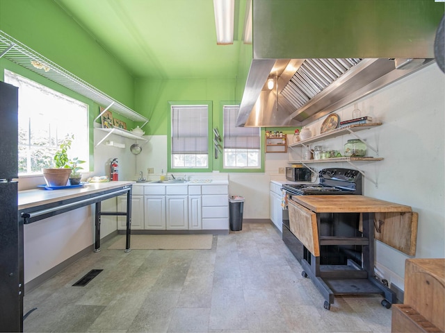 kitchen with white cabinetry, range hood, sink, and black appliances