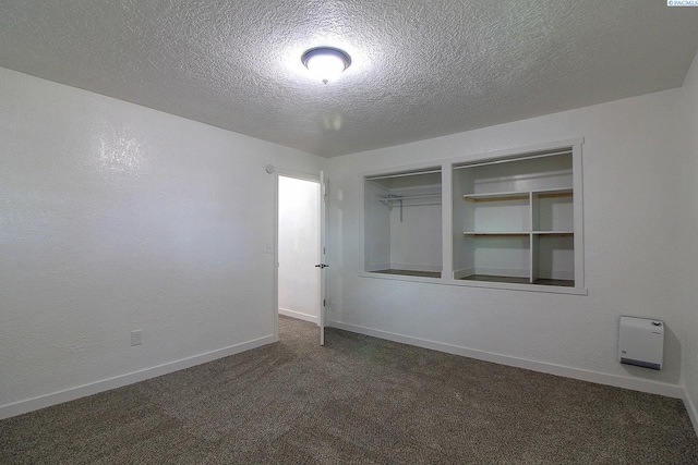 unfurnished bedroom featuring baseboards, a textured wall, a textured ceiling, carpet flooring, and a closet