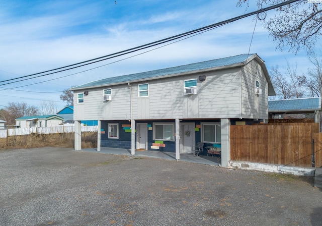 view of front of house with metal roof and fence