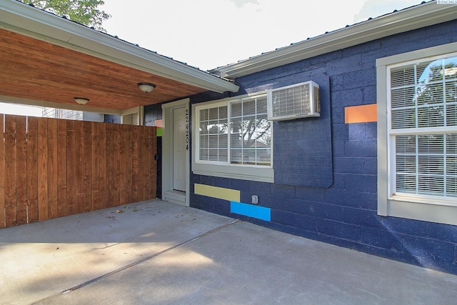 view of side of home featuring a patio area and concrete block siding