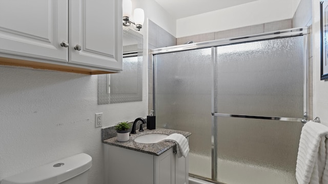 2404 Camden St, Richland, WA 99352 - bathroom with toilet, vanity, a shower with shower door, and a textured wall