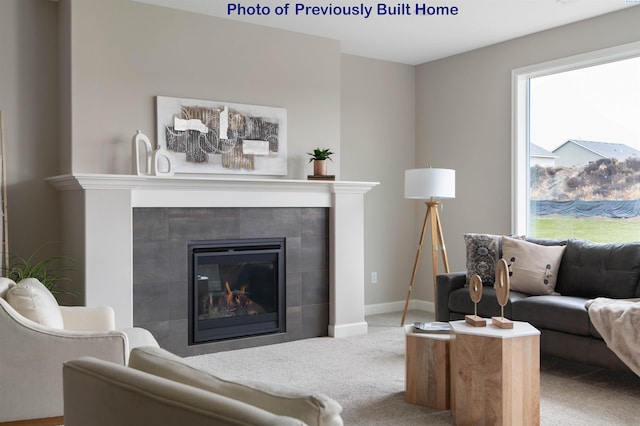 carpeted living room with baseboards and a tiled fireplace