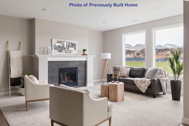 living area with carpet flooring, a tile fireplace, and baseboards