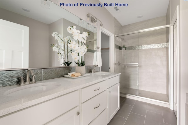 bathroom with double vanity, visible vents, a sink, and tile patterned floors