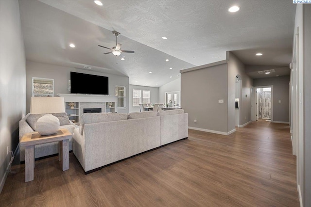 234 Ladera St, Prosser, WA 99350 - living area featuring a textured ceiling, a fireplace, wood finished floors, baseboards, and vaulted ceiling