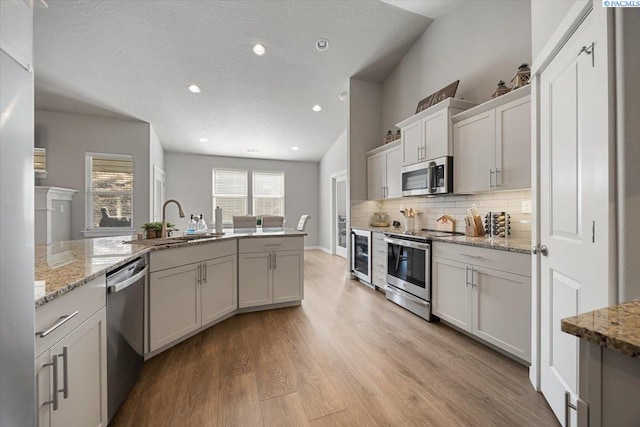 234 Ladera St, Prosser, WA 99350 - kitchen featuring wine cooler, tasteful backsplash, light wood-style flooring, appliances with stainless steel finishes, and a sink