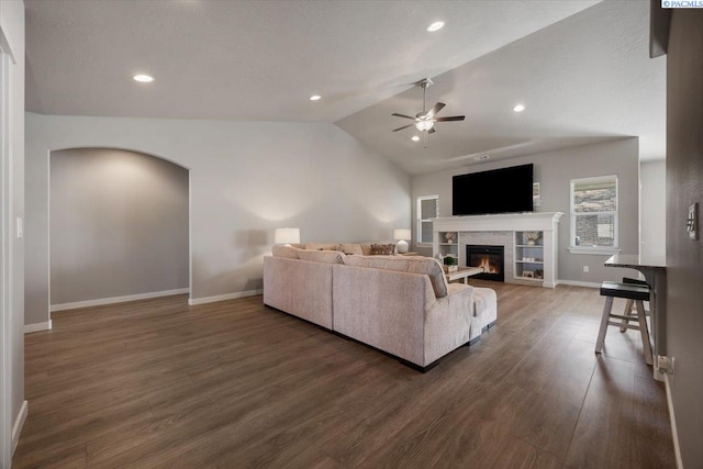 234 Ladera St, Prosser, WA 99350 - living area with baseboards, dark wood finished floors, a tiled fireplace, lofted ceiling, and ceiling fan