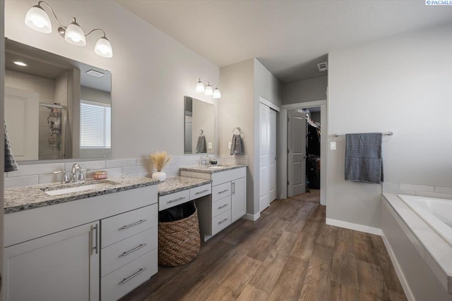 234 Ladera St, Prosser, WA 99350 - bathroom featuring baseboards, wood finished floors, a spacious closet, vanity, and a shower stall