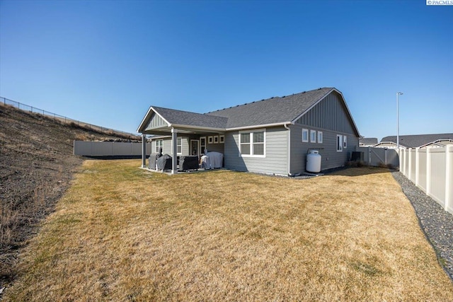 234 Ladera St, Prosser, WA 99350 - rear view of property featuring board and batten siding, a fenced backyard, a lawn, and roof with shingles