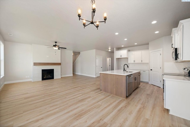 7136 W 28th Pl, Kennewick, WA 99338 - kitchen featuring appliances with stainless steel finishes, an island with sink, ceiling fan, light wood-style floors, and a chandelier