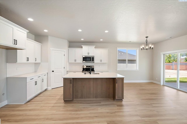 7136 W 28th Pl, Kennewick, WA 99338 - kitchen featuring stainless steel microwave, a chandelier, tasteful backsplash, light countertops, and recessed lighting