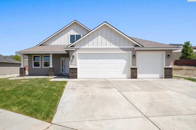 7136 W 28th Pl, Kennewick, WA 99338 - craftsman inspired home with stone siding, a garage, concrete driveway, board and batten siding, and a shingled roof