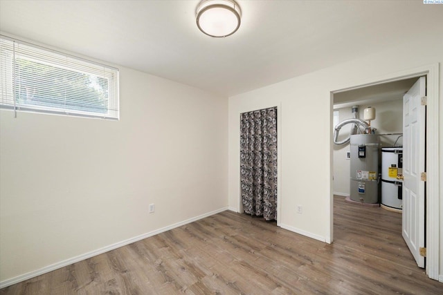 1205 N Union St, Kennewick, WA 99336 - unfurnished bedroom with secured water heater, wood finished floors, and baseboards