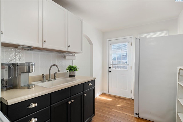 1205 N Union St, Kennewick, WA 99336 - kitchen with freestanding refrigerator, a sink, dark cabinetry, tasteful backsplash, and light wood finished floors