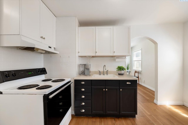 1205 N Union St, Kennewick, WA 99336 - kitchen featuring range with electric cooktop, a sink, white cabinetry, light wood-style floors, and backsplash