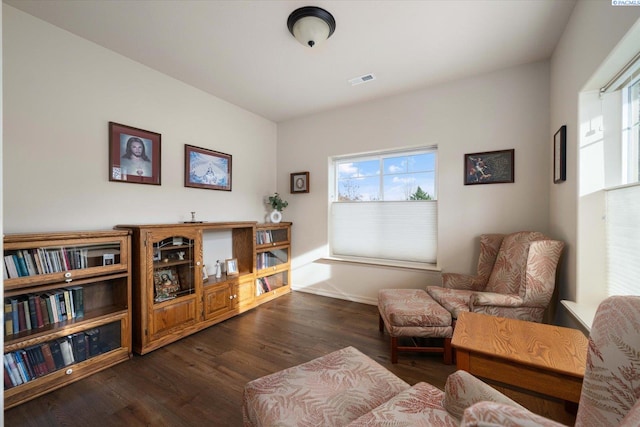 sitting room featuring dark wood-type flooring and a healthy amount of sunlight