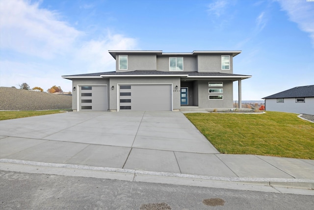 prairie-style house featuring a porch, a garage, concrete driveway, stucco siding, and a front lawn