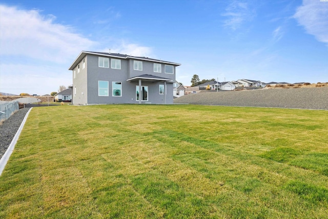 back of house with a yard, a fenced backyard, and stucco siding