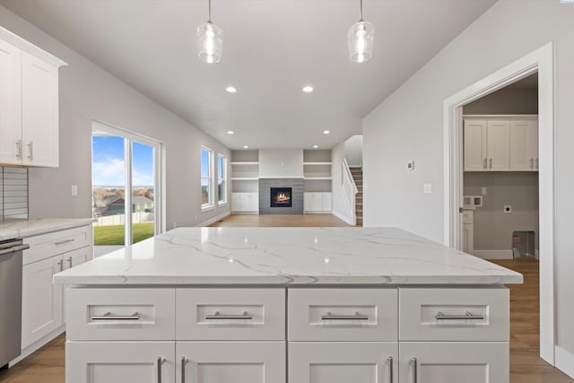 kitchen with white cabinets, a kitchen island, and pendant lighting