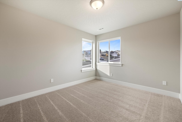 carpeted empty room with baseboards