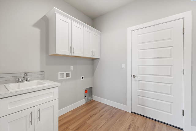 washroom with hookup for a washing machine, cabinet space, a sink, electric dryer hookup, and baseboards