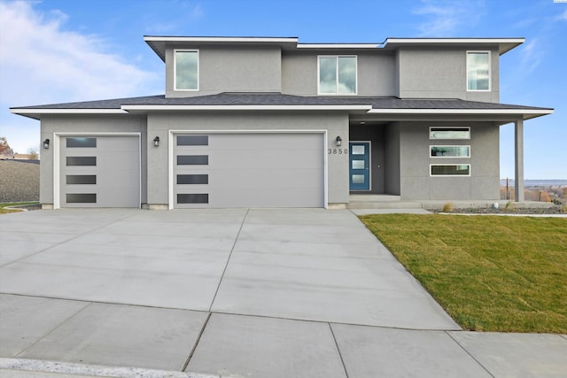 prairie-style house featuring driveway, stucco siding, an attached garage, covered porch, and a front yard