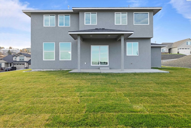 back of property featuring a patio area, a lawn, and stucco siding