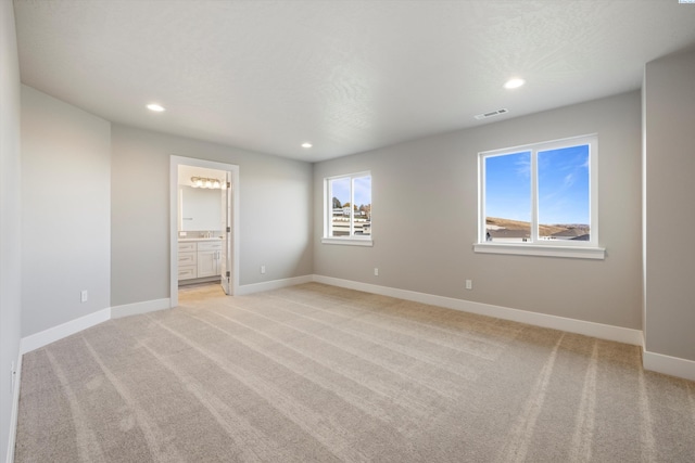 unfurnished bedroom featuring light carpet, baseboards, visible vents, and recessed lighting