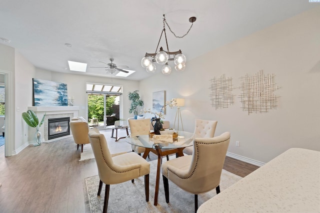 9411 Vincenzo Dr, Pasco, WA 99301 - dining area with wood finished floors, a fireplace with flush hearth, and a skylight