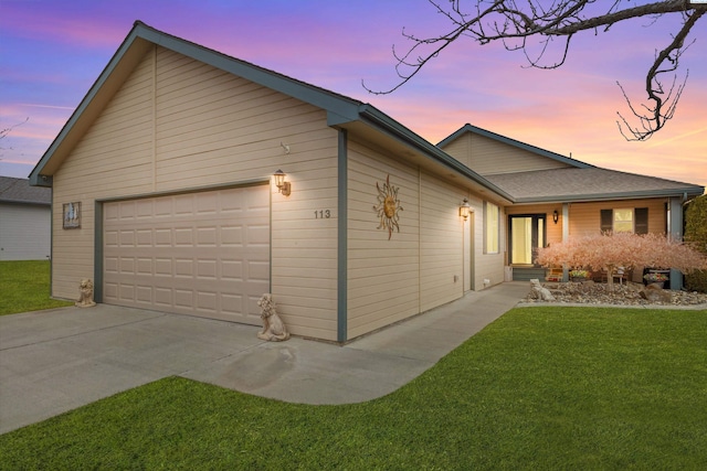 ranch-style home with a garage and a yard